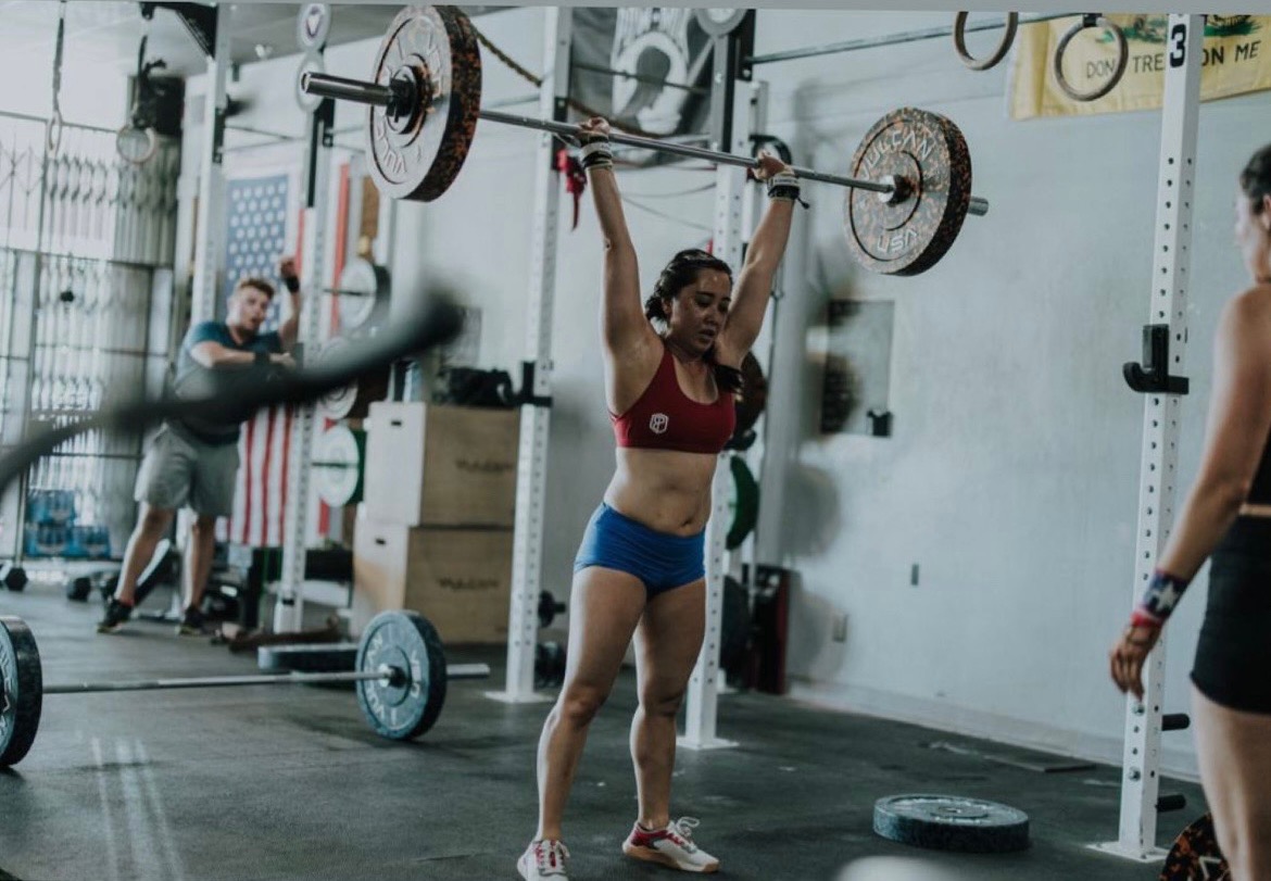 A TruFitness4Life client completing an overhead barbell lift in the gym