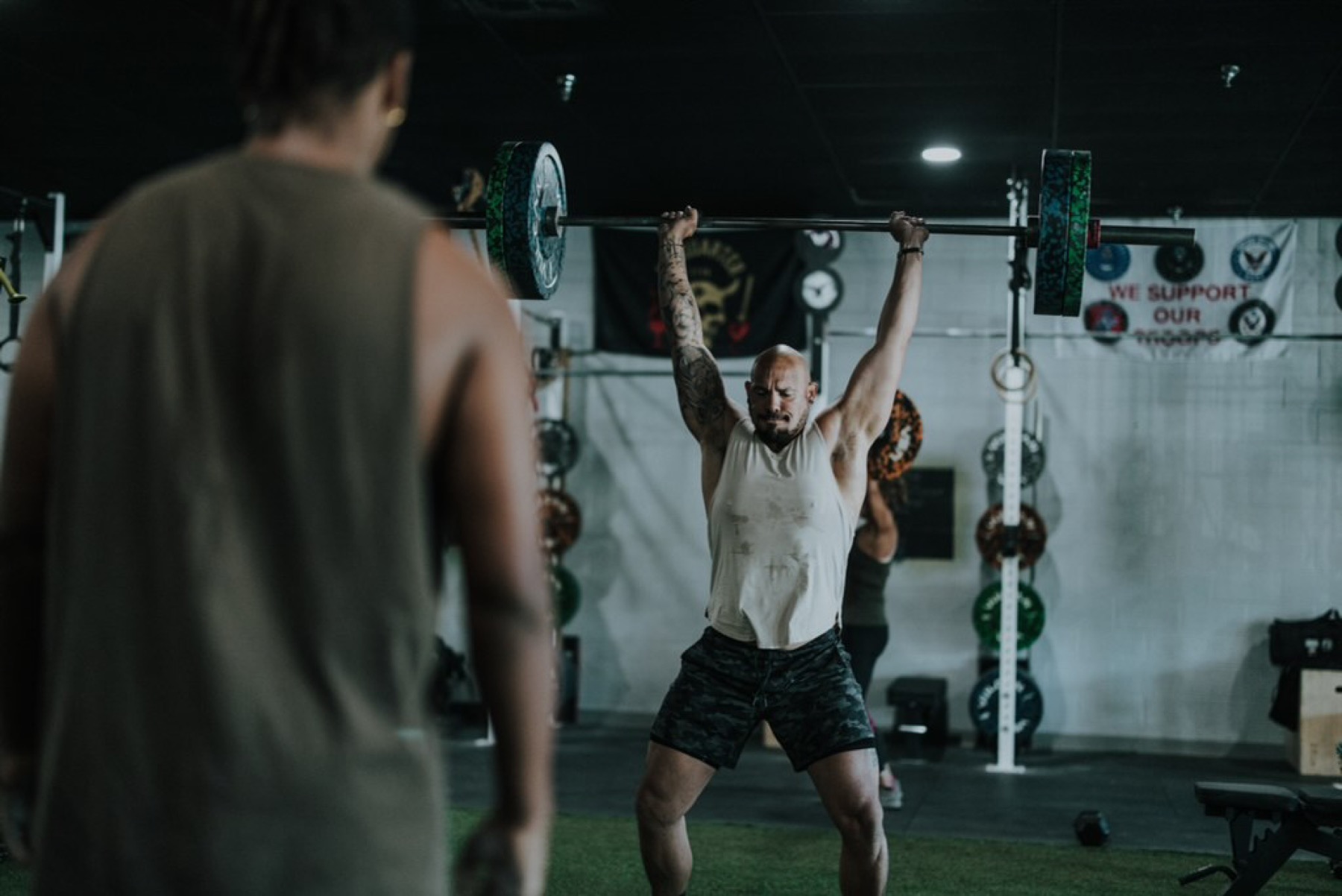 The TruFitness4Life coach lifting a barbell overhead in the gym